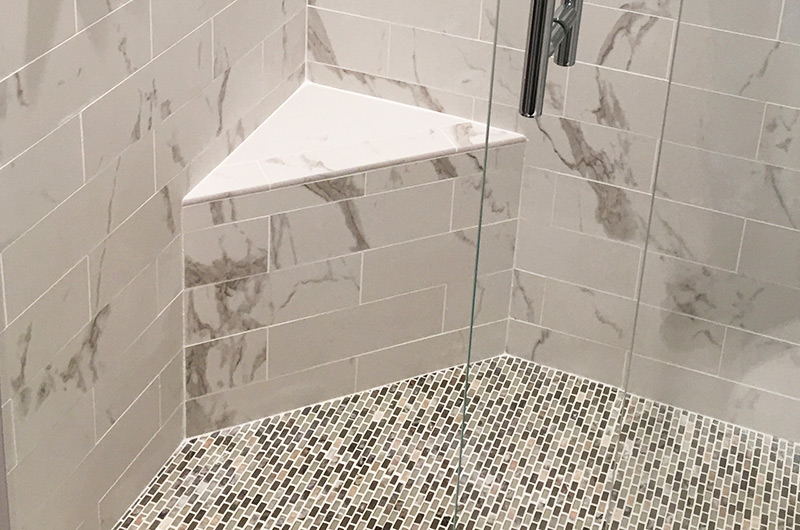 Mosaic floor tiles built-in shower bench grab bar