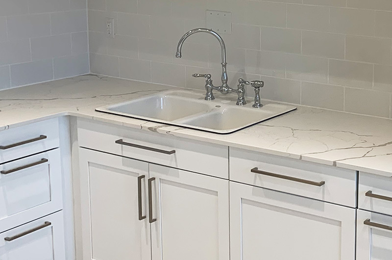 Light gray subway tile backsplash with integrated power outlets