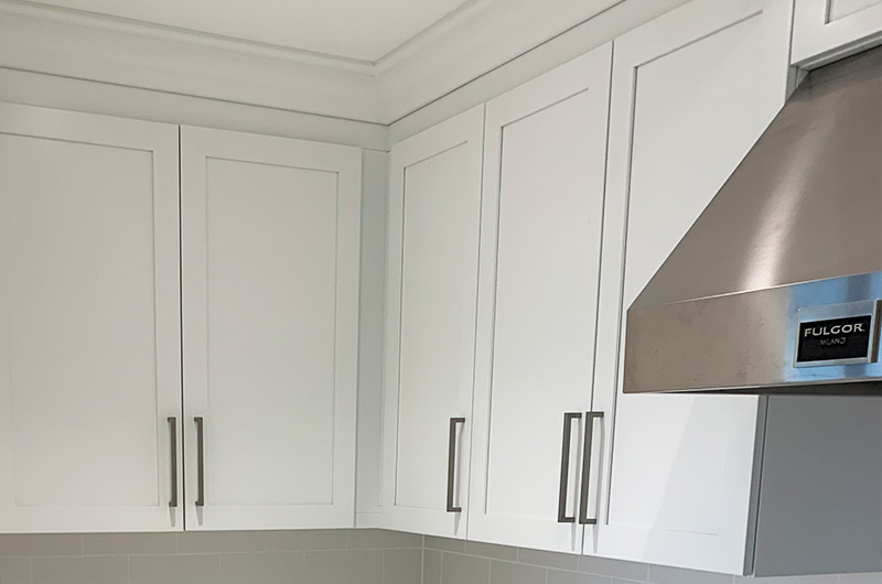 Close-up of upper wall cabinets with minimalist doors and built-in lighting